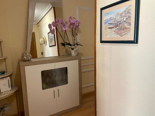 a room with a cabinet with a vase of flowers on it at Un Lugar Para Descansar En Alicante in Alicante