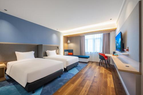 a hotel room with two beds and a desk at Holiday Inn Express Jurong Xianlin in Zhenjiang