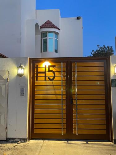 a wooden garage door with the letter h on it at اتش h5 ينبع الصناعية in Madīnat Yanbu‘ aş Şinā‘īyah