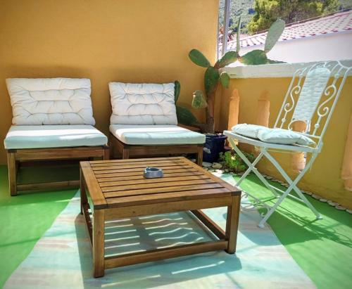 2 Stühle und ein Couchtisch auf einer Terrasse in der Unterkunft Beautiful Vintage House in Vis
