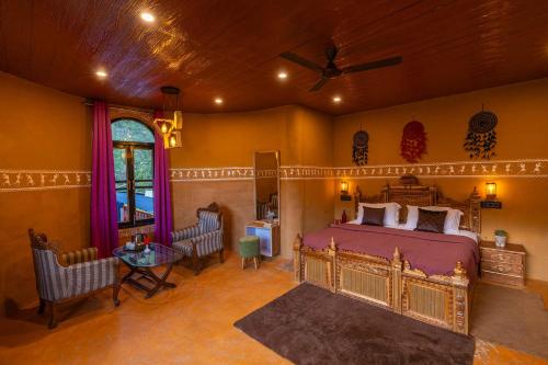 a bedroom with a king sized bed and a table at Dharamalaya by StayVista - The Eco Home in Dharamshala