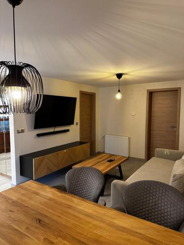 ein Wohnzimmer mit einem Esstisch und einem TV in der Unterkunft Glamping Laško in Laško
