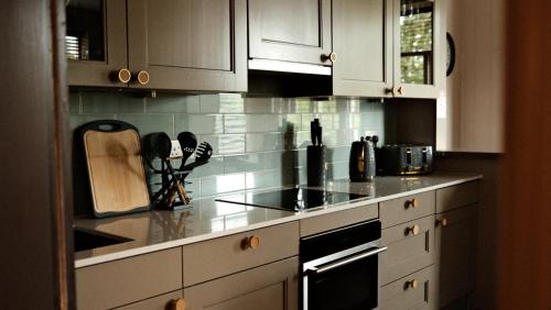 a kitchen with white cabinets and a counter top at The Lawrance Luxury Aparthotel - Harrogate in Harrogate