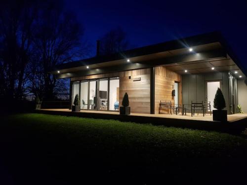 a small house with lights on it at night at Landscape, New Eco Lodge Flatford Mill in East Bergholt