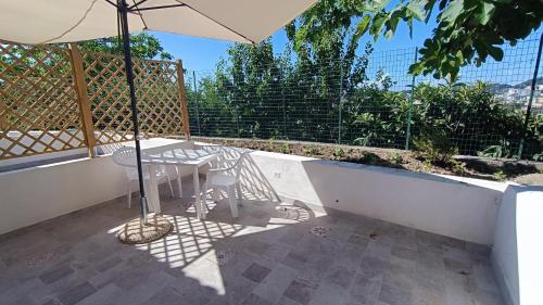 a patio with a table and an umbrella at Passariello in Ischia