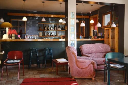 a bar with chairs and a couch and a table at Red Goat Hostel in Tirana