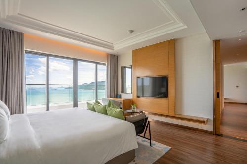 a bedroom with a large bed and a large window at Grand Hyams Hotel - Quy Nhon Beach in Quy Nhon