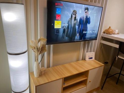 a living room with a tv on a wall with a table at Cozy Condo in San Jose Del Monte Bulacan Loft 2109 in Tunkong Manga