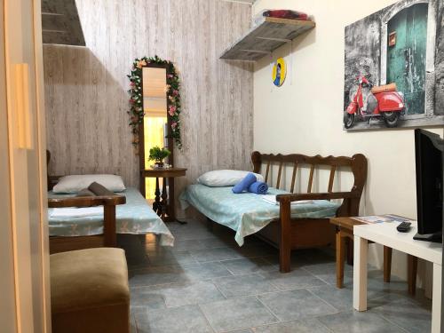 een kamer met twee bedden en een scooter aan de muur bij Converted Shed Studio & Garden Hanging Bed in Porto Rafti
