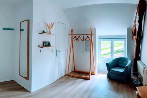 Zimmer mit einem Spiegel und einem blauen Stuhl in der Unterkunft Ferme de Gratteloup 