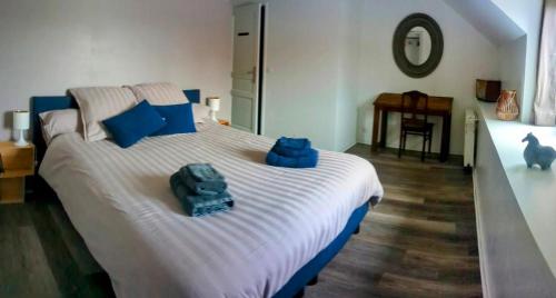 ein Schlafzimmer mit einem großen Bett mit blauen Handtüchern darauf in der Unterkunft Ferme de Gratteloup 