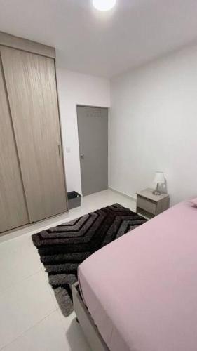 una camera bianca con letto e specchio di Apartamento muy cerca al Mar de 3 habitaciones a Cartagena de Indias
