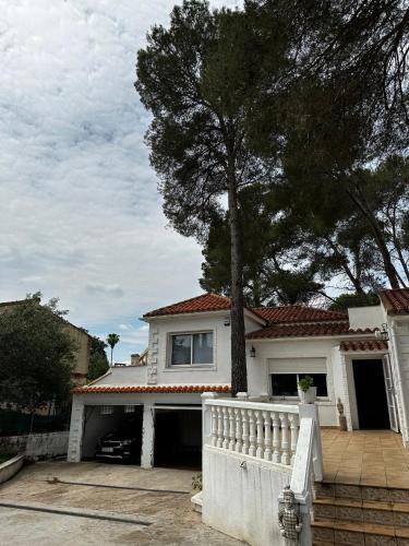uma casa branca com uma árvore em frente em Villa Rosa Rasero 