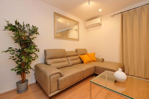 a living room with a brown couch and a mirror at ACOE HATSUDAI - 4BR Entire Home Upscale Area in Tokyo
