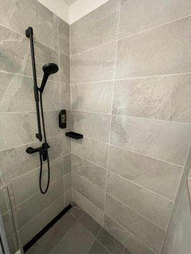 a bathroom with a shower with a tile wall at Skyfall Rooms in Eisenstadt