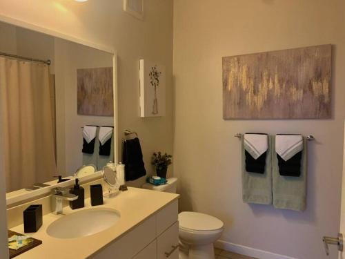 een badkamer met een wastafel, een toilet en een spiegel bij Contemporary Cozy Apartment in Baltimore