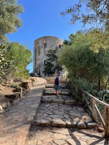 a person walking down a stone path in front of a castle at Casa Funtana e Susu in Jerzu