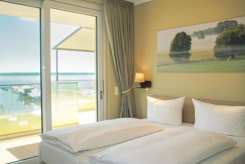 a bedroom with a bed with a view of the ocean at Appartements "Zum Leuchtturm" Hafen Rankwitz Insel Usedom in Rankwitz
