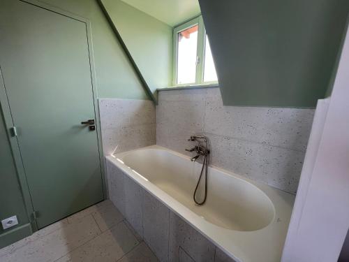La salle de bains est pourvue d'une baignoire et d'une fenêtre. dans l'établissement La Maison à Pan De Bois chambre Art Deco, à Vierzon