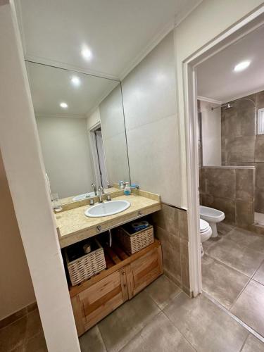 a bathroom with a sink and a toilet and a mirror at Bungalow Don Árbol in Colón