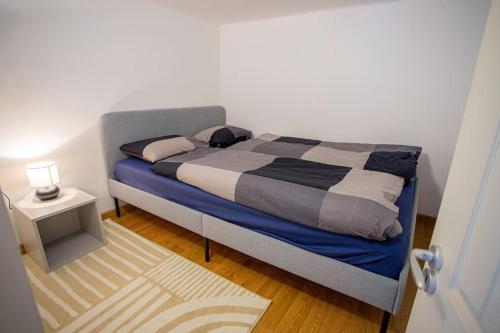 1 dormitorio con 1 cama y 1 mesa con lámpara en Two bedroom gallery flat in the Akacfa str., en Budapest