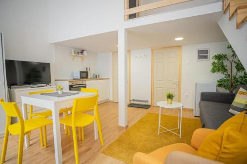 sala de estar con mesa y sillas amarillas en Two bedroom gallery flat in the Akacfa str., en Budapest