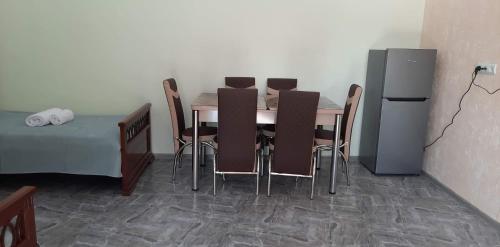 einen Esstisch mit 4 Stühlen und einen Kühlschrank in der Unterkunft new garni 1 in Garni
