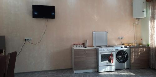 eine Küche mit einer Waschmaschine und einem TV an der Wand in der Unterkunft new garni 1 in Garni