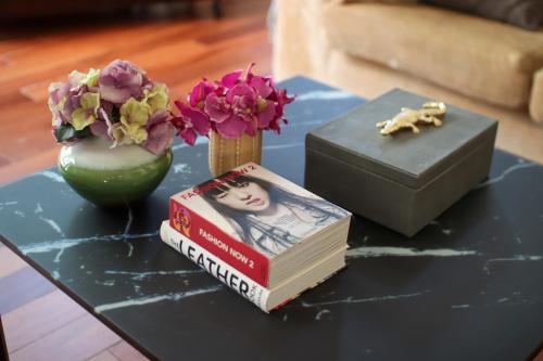 a table with a book and a box and flowers at Casa Boticario in Mairena del Aljarafe