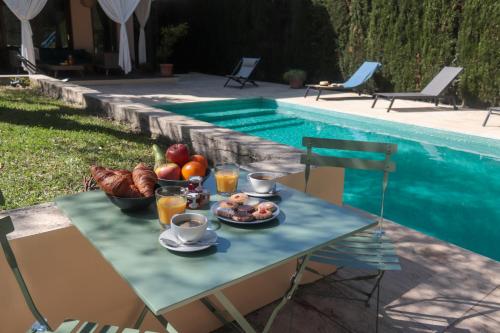 a table with a plate of food next to a pool at Casa Boticario in Mairena del Aljarafe