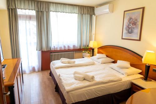 Habitación de hotel con 2 camas y toallas. en Majerik Hotel, en Hévíz