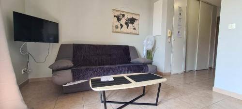 a living room with a couch and a coffee table at Appartement DisneyLand Montevrain in Montévrain