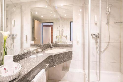 a bathroom with a sink and a shower at Best Western Plus Hotel Am Schlossberg in Nürtingen