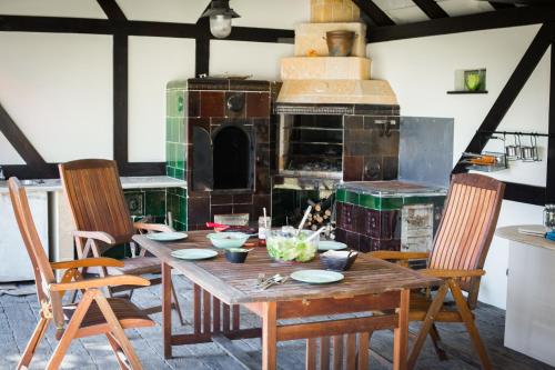 a kitchen with a wooden table with chairs and an oven at Dom wakacyjny - wiatrak holenderski na Mazurach in Ryn