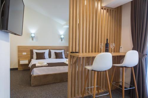 sypialnia z łóżkiem i 2 białymi krzesłami w obiekcie Rooftop Apartments & Rooms w Budvie