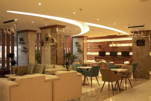 eine Hotellobby mit Sofas, Tischen und Stühlen in der Unterkunft Sparrow Apartments Hotel in Dschidda