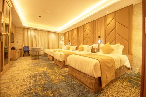 eine Reihe von Betten in einem Hotelzimmer in der Unterkunft Sparrow Apartments Hotel in Dschidda