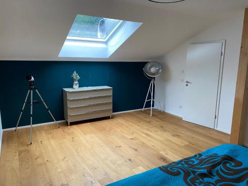 sypialnia z niebieską ścianą i świetlikiem w obiekcie Alpenland Apartments w mieście Aschau im Chiemgau
