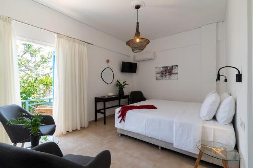 a bedroom with a white bed and a balcony at Hotel Matina in Kamari
