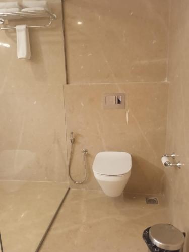 a bathroom with a white toilet and a shower at UVA Sands Beach Resort in Kundapur