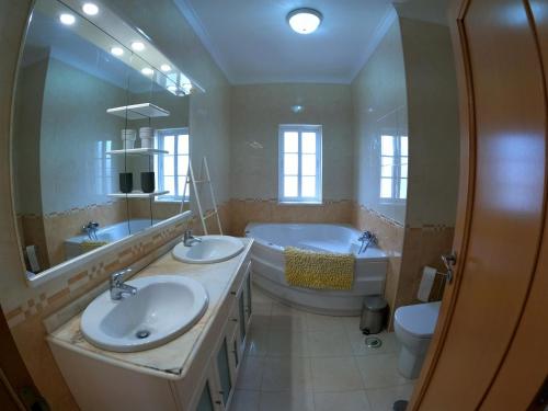een badkamer met 2 wastafels, een bad en een toilet bij Luxury Apartment 4 Bedrooms Pool in Marisol in Corroios