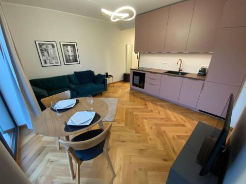 eine Küche und ein Wohnzimmer mit einem Tisch und einem Sofa in der Unterkunft Cozy apartment near the beach and the city center in Tartu