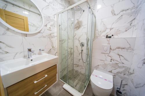 y baño con ducha, aseo y lavamanos. en Rooftop apartments & rooms Budva en Budva