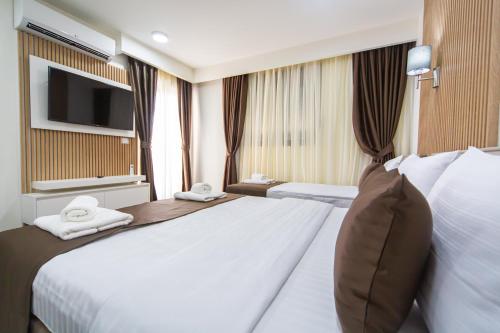Habitación de hotel con cama grande y TV en Rooftop Apartments & Rooms, en Budva