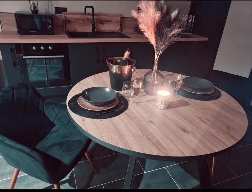 - une table en bois avec une bougie et un vase dans l'établissement Les étonnants romantiques, à Combourg