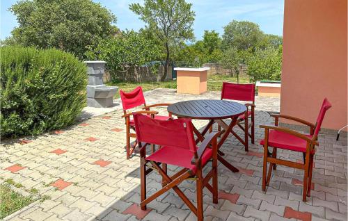 a patio with a table and four red chairs at Nice Home In Knin With Kitchen 