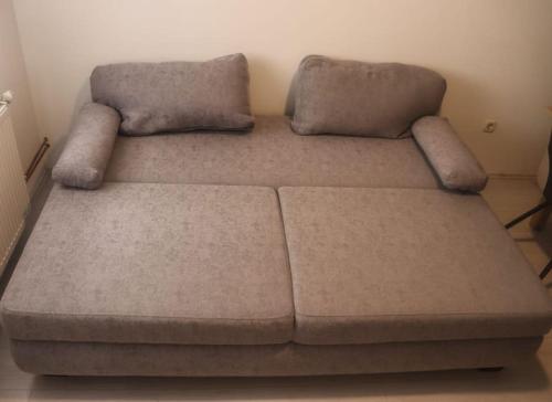 um sofá castanho com duas almofadas em cima em Apartman Matea em Topići