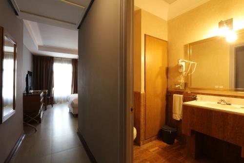 a bathroom with a sink and a large mirror at Hôtel Les Saisons in Casablanca