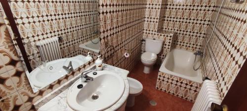 een badkamer met een wastafel, een toilet en een bad bij Piso céntrico cerca de la feria y la catedral in Albacete