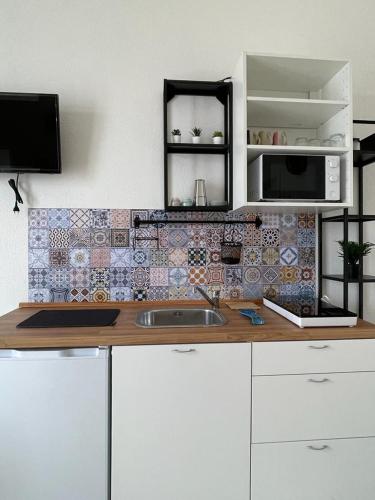 a kitchen counter with a sink and a microwave at Terra De Mare in Palmariggi